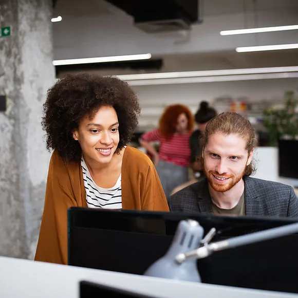 Two colleagues reviewing an automated workflow on screen