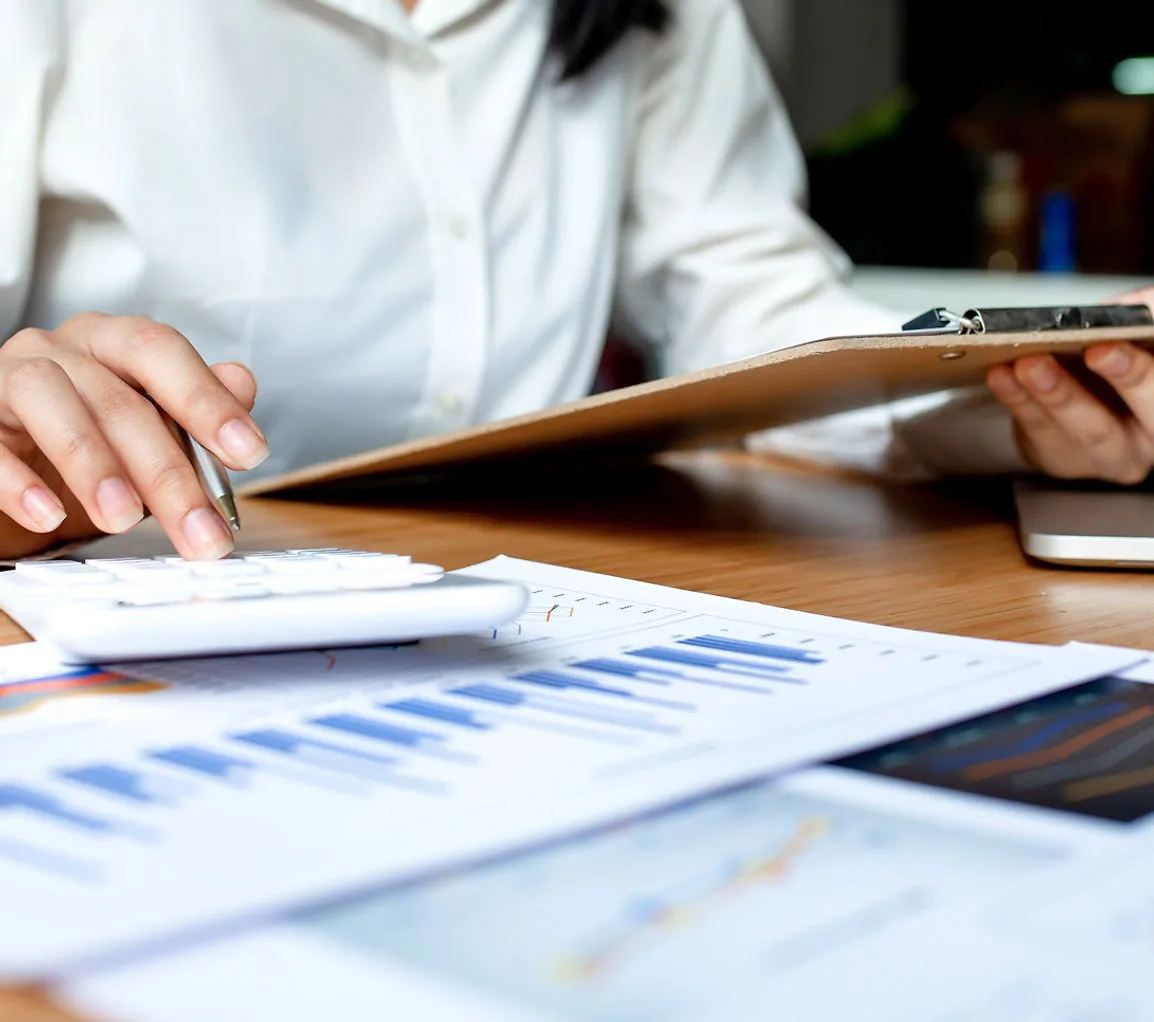 An analyst working through property performance figures on paper