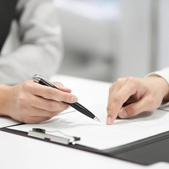 Two people reviewing and signing a property contract